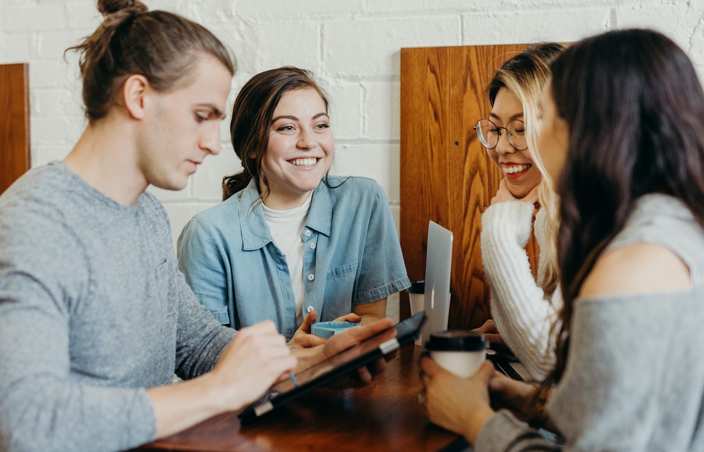 Four people talking together around a cafe table