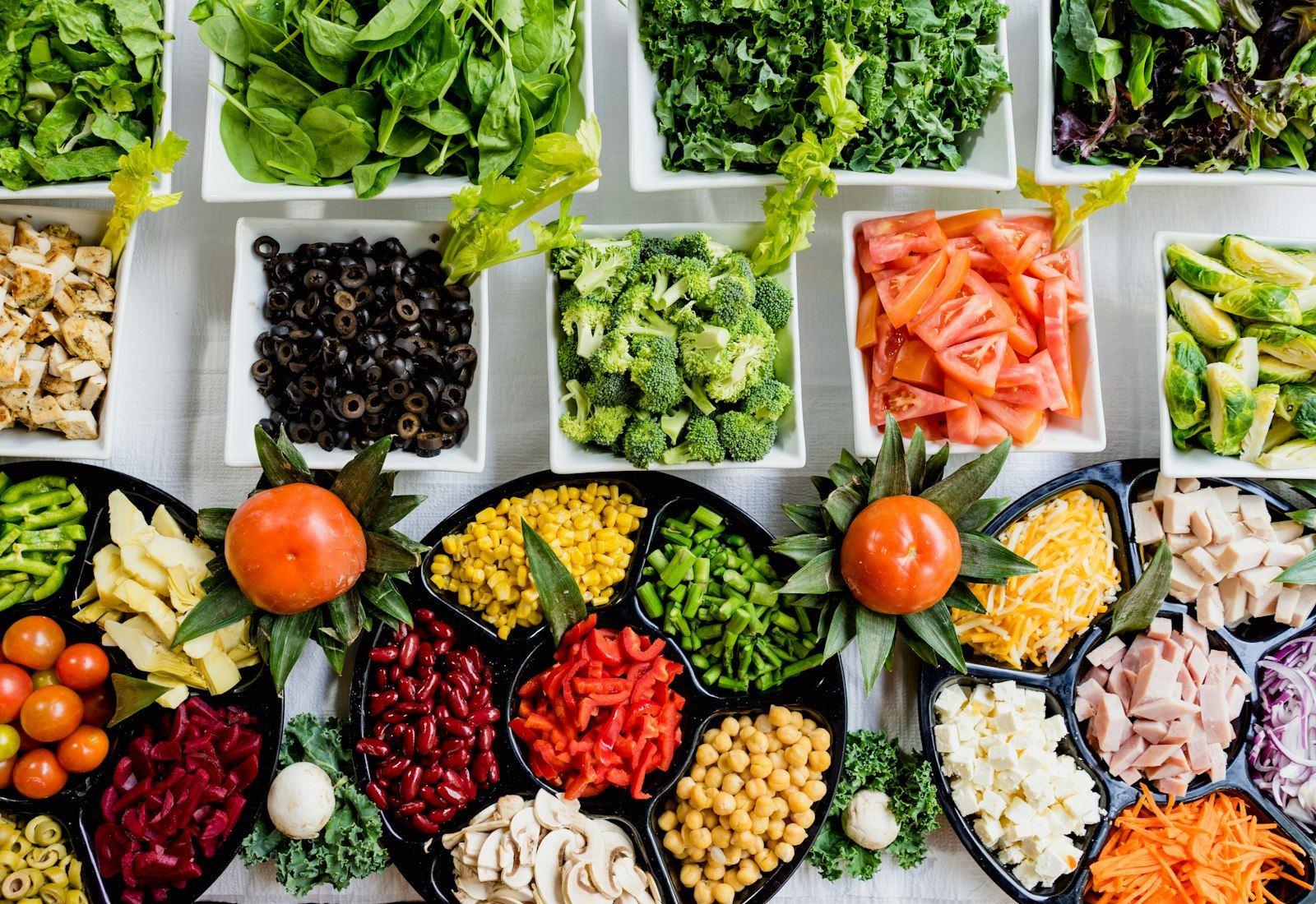 Bowls of vegetables and simple prepared food on a light table